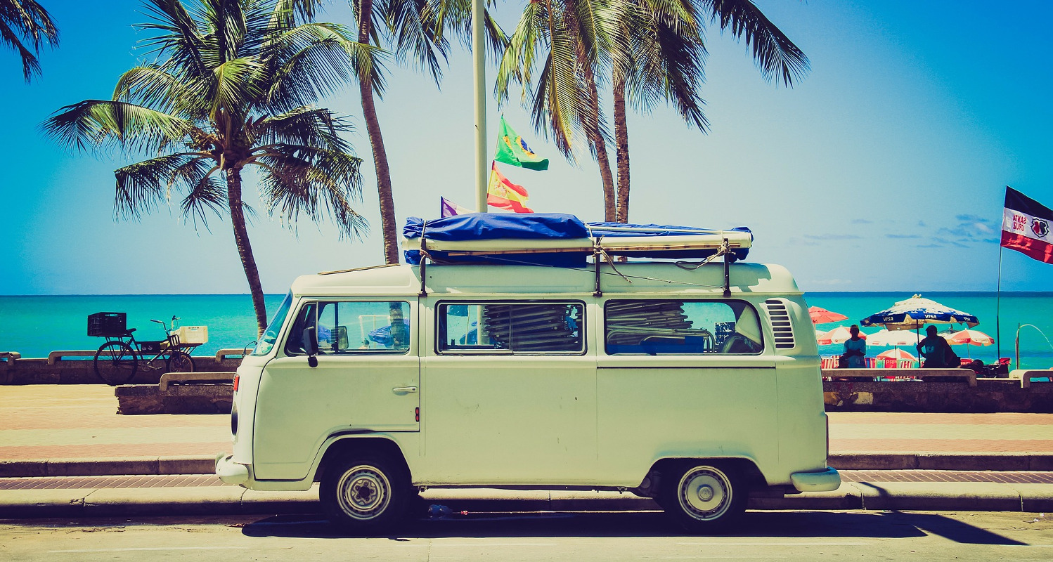 Vintage VW campervan with palm trees and sea