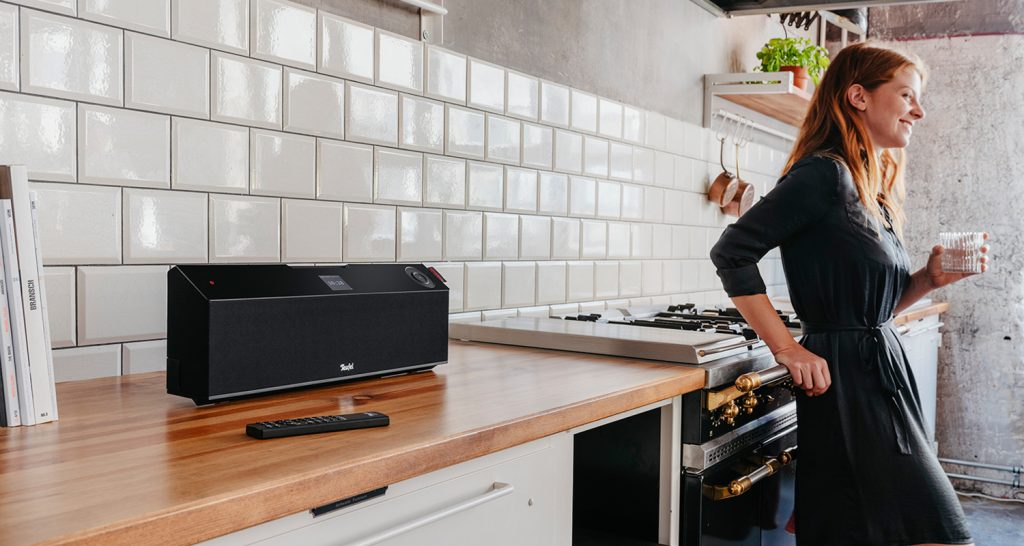 Frau steht in einer Küche, auf der Anrichte MUSICSTATION von Teufel