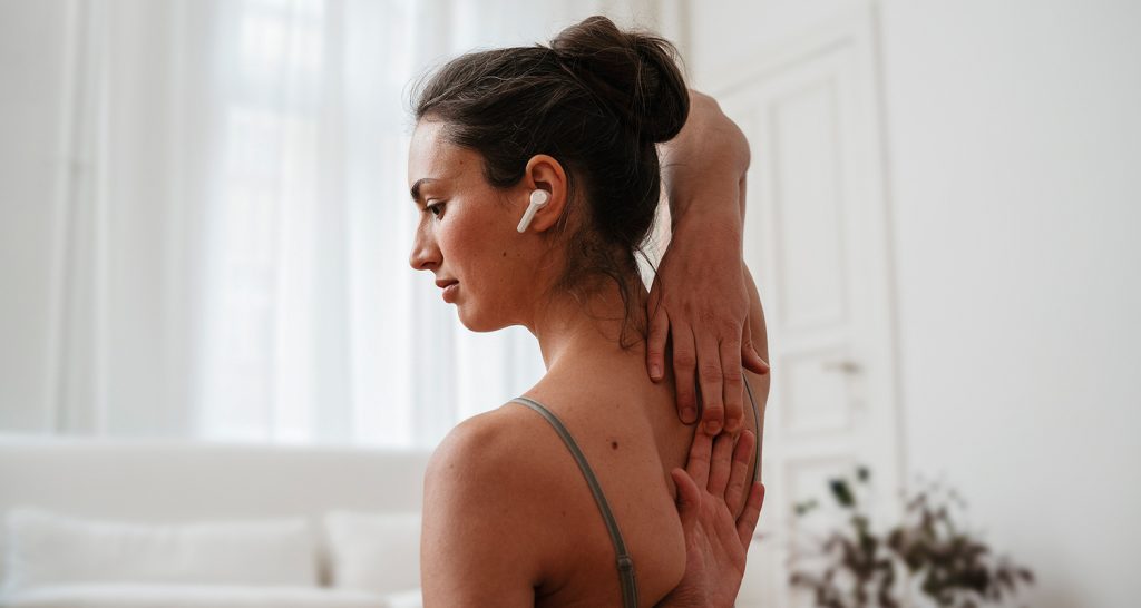 A woman wearing Teufel's AIRY TWS 2 while practicing yoga.